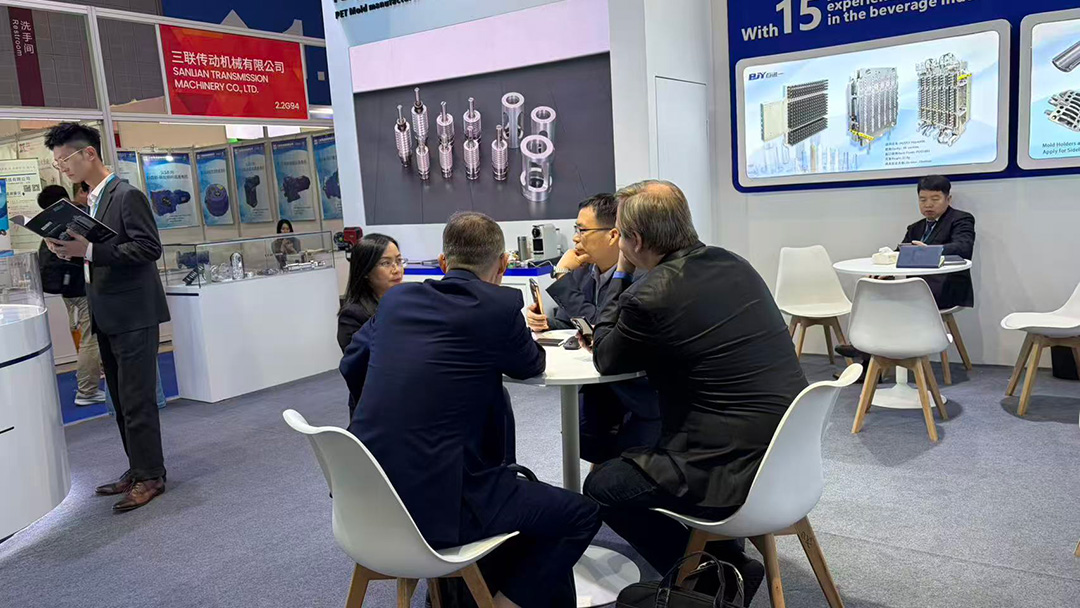 International customers discuss PET preform mold, blow mold, and capping mold solutions with the BJY engineering team during Chinaplas 2026.