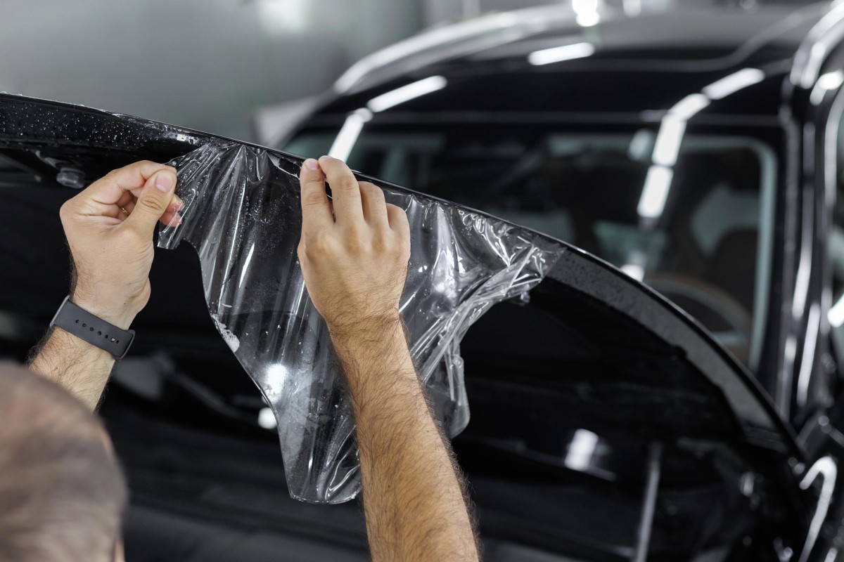 technician stretching paint protection film during manual installation