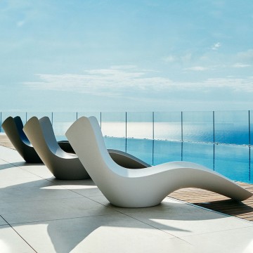 white s shaped resin pool sun lounger chairs in water