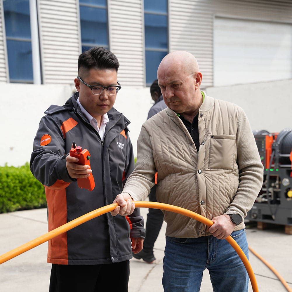 AMJET engineer explaining high pressure sewer jetter hose operation to customer.jpg