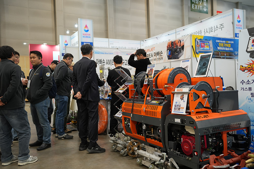 amjet sewer jetter machine exhibition display with plumbers visiting booth.jpg