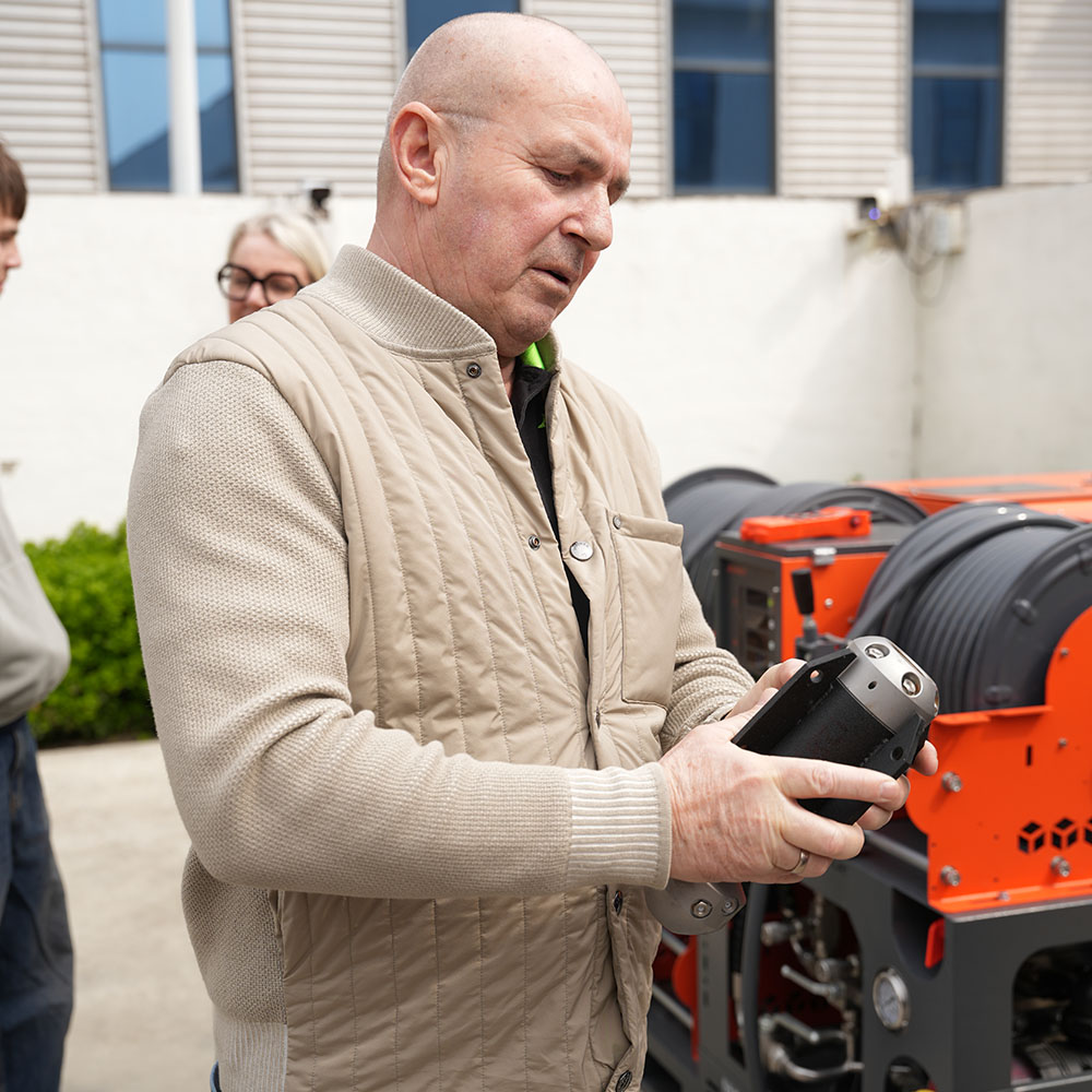 Customer inspecting AMJET sewer jetter components during factory tour.jpg