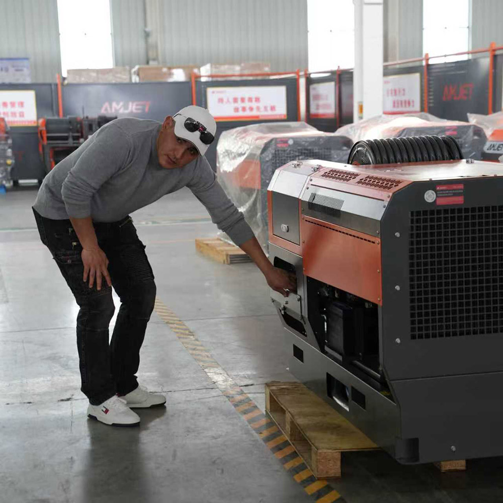 Professional plumber inspecting AMJET sewer jetter machine build quality at factory.jpg