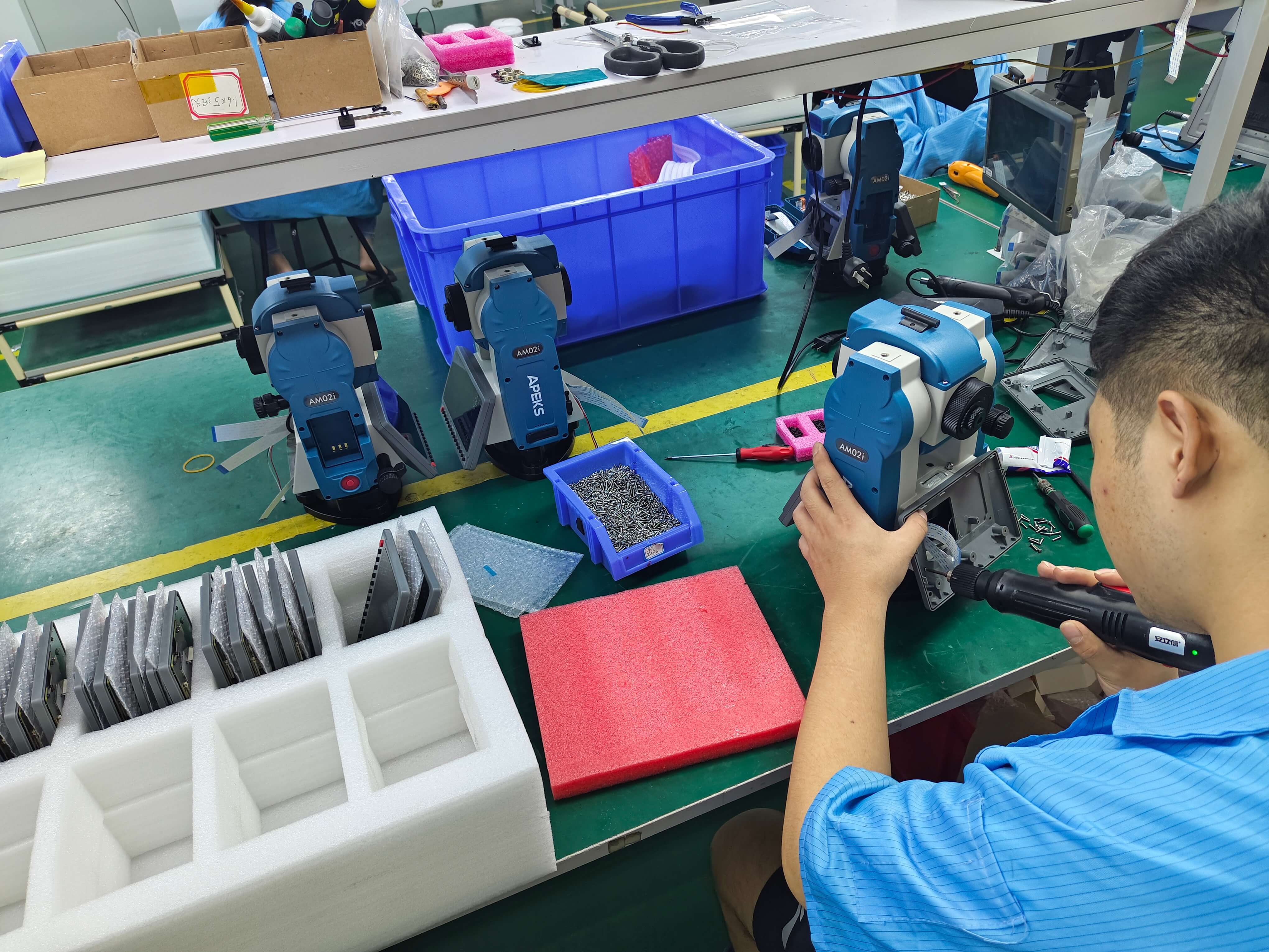 Technician assembling touch display modules and housing on the APEKS AM02i total station