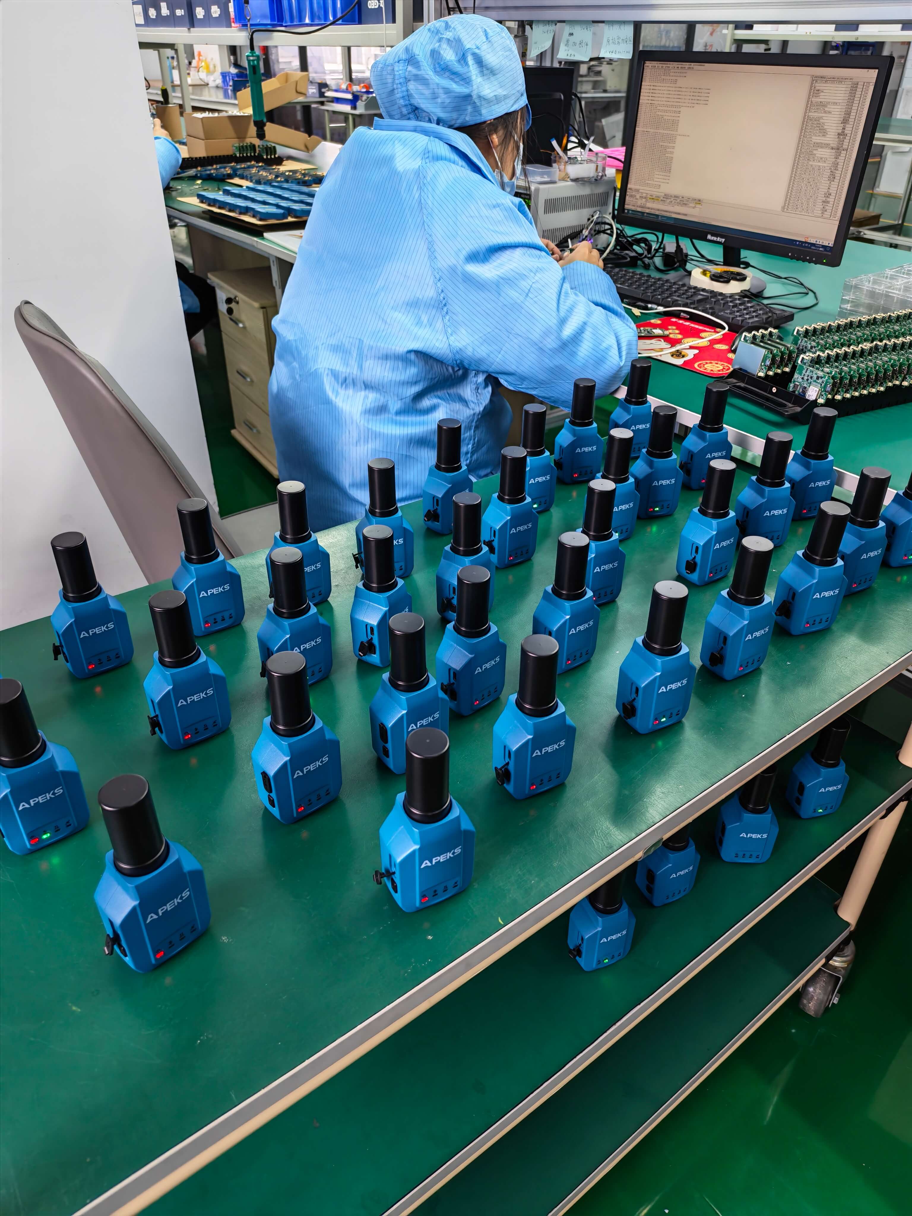 Array of completed APEKS APS1 compact RTK receivers on the production line workbench