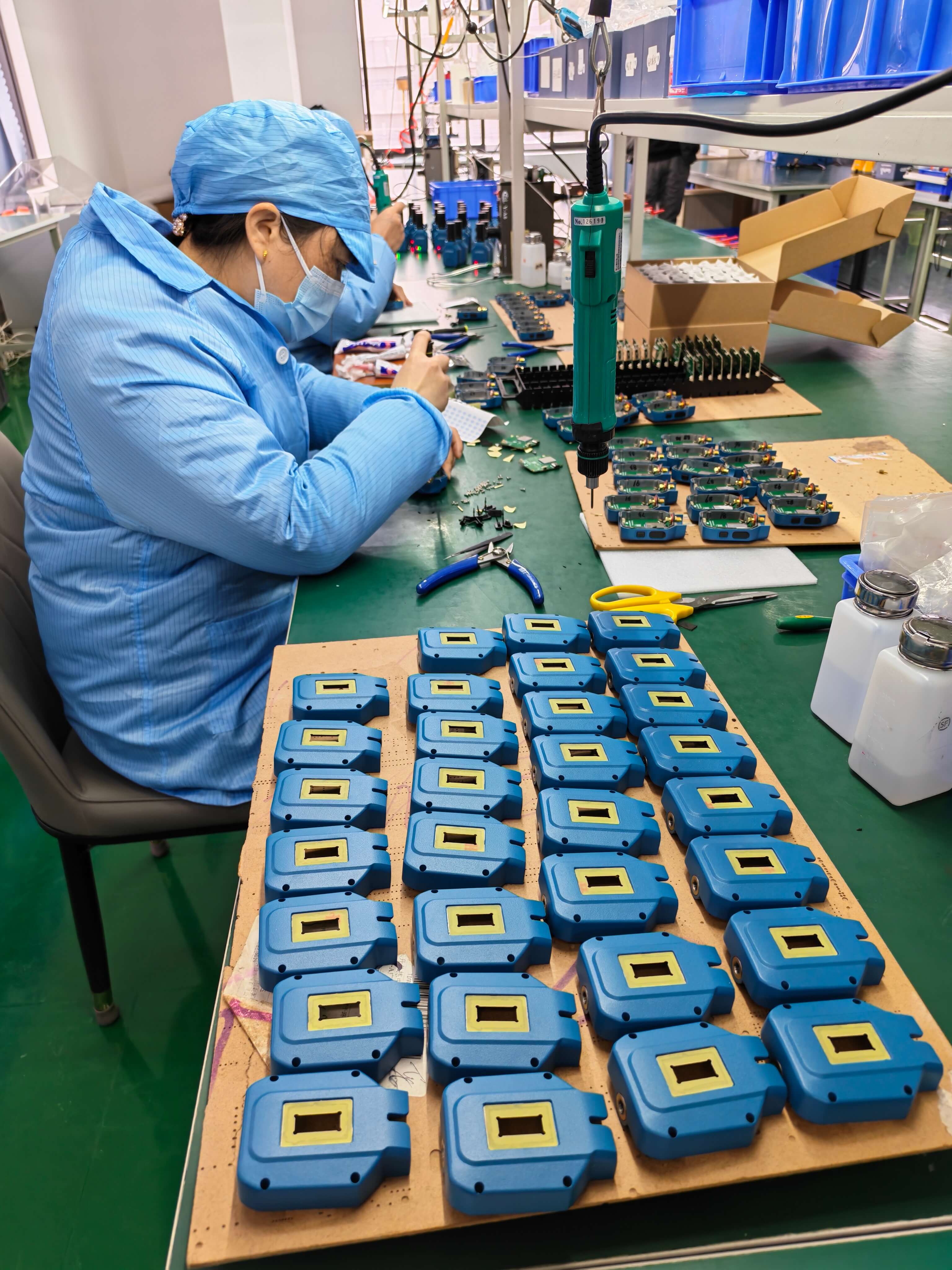 Factory technician assembling casing and PCB boards for APEKS APS1 handheld RTK receivers