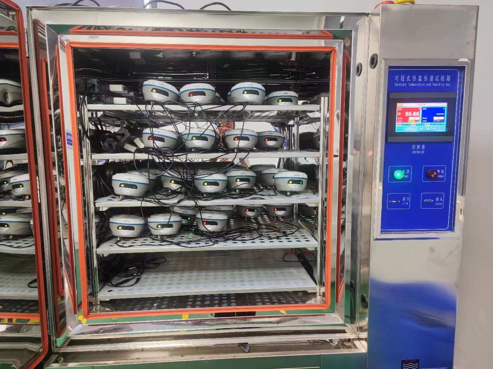 APEKS GNSS receivers undergoing high-temperature and humidity aging testing in a programmable environmental chamber