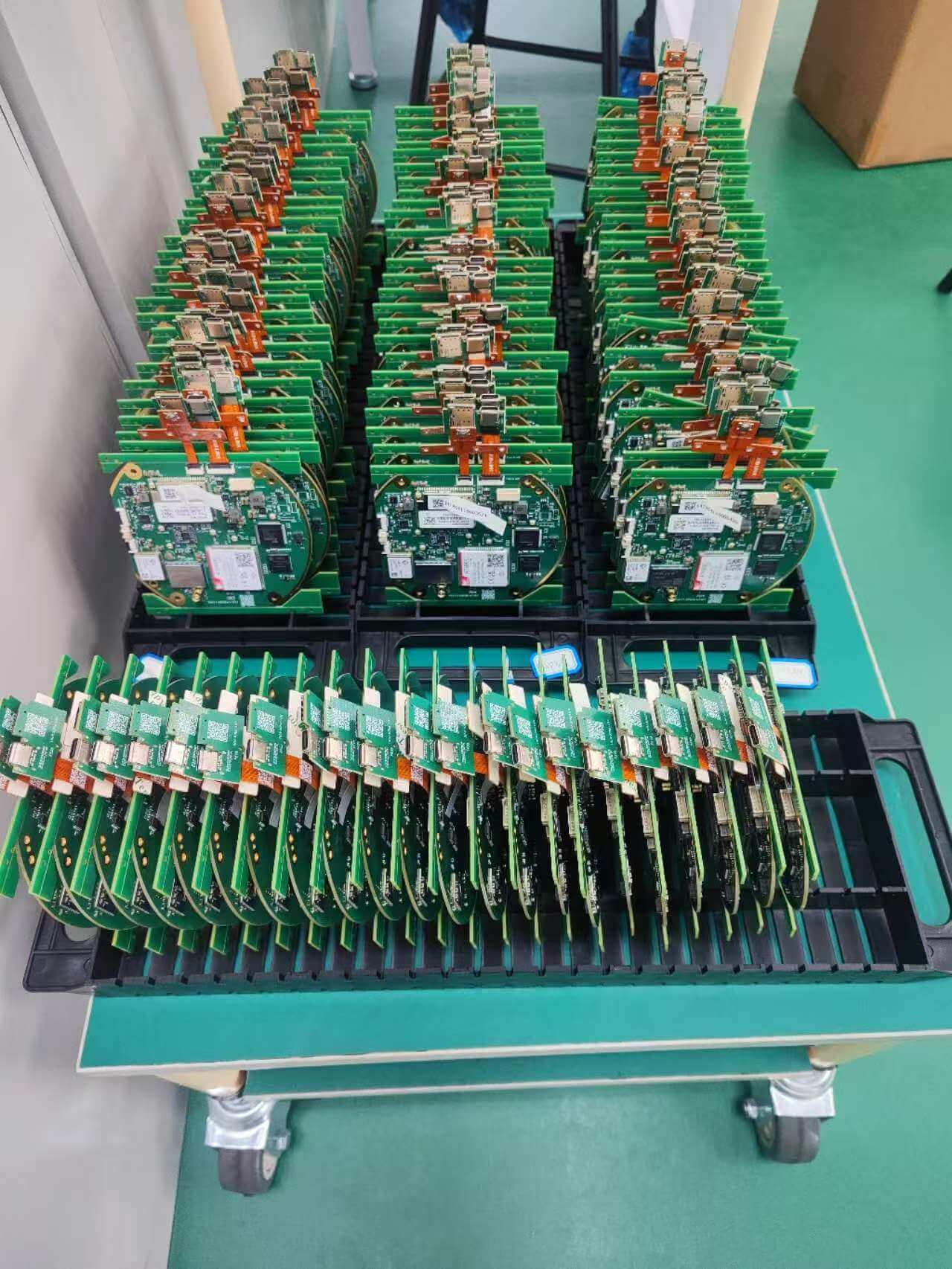 Rows of assembled and tested GNSS receiver core circuit boards and motherboards ready for housing integration