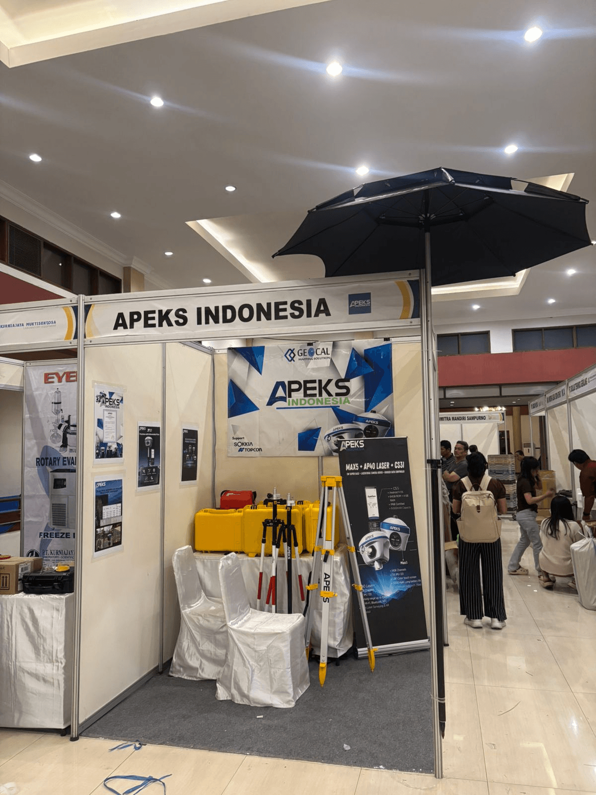 APEKS Indonesia exhibition booth showcasing AP40 Laser RTK rovers, MAX5 base stations, and surveying gear at the PPLPI 2026 event in Lombok