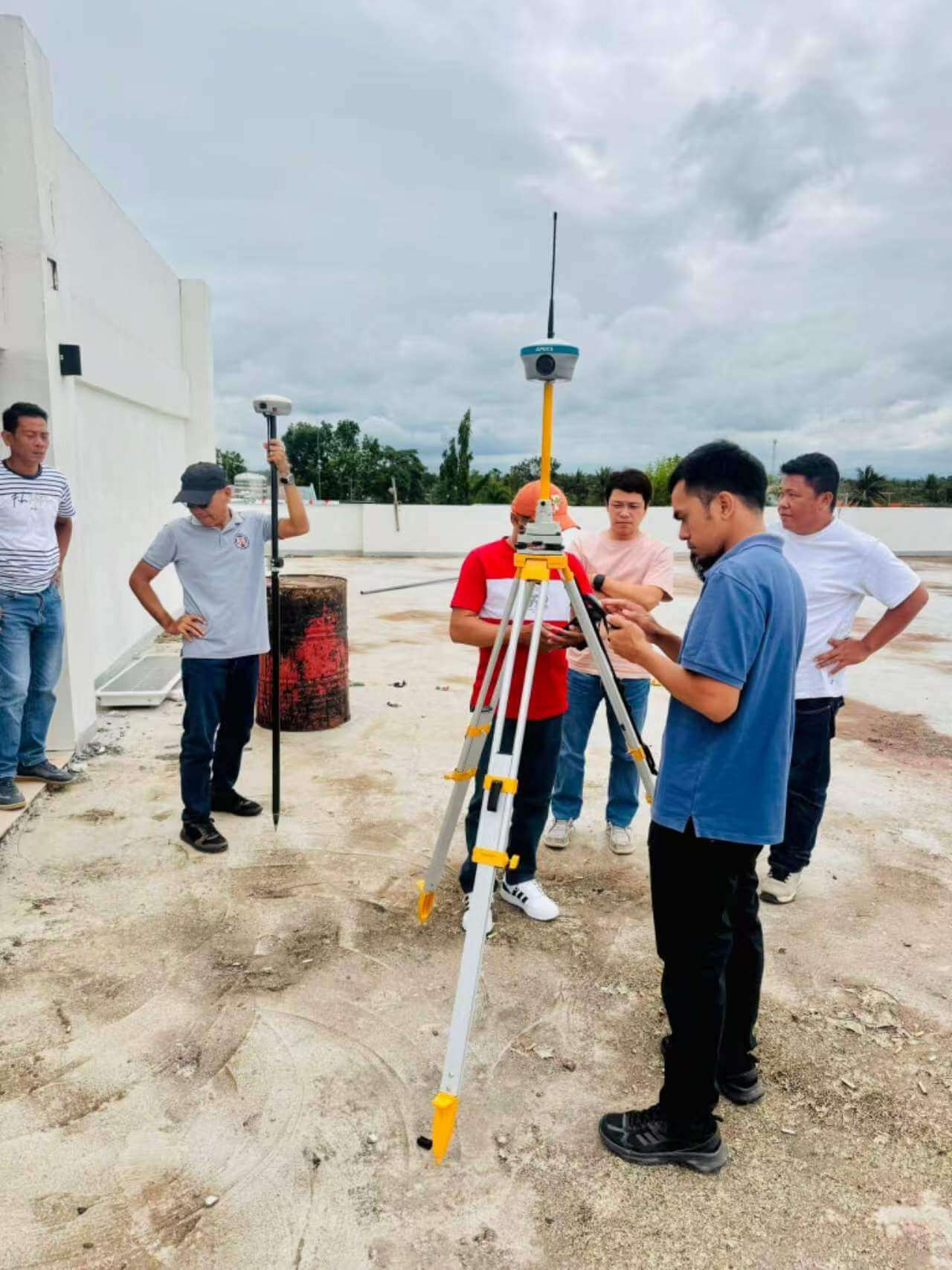 Field team calibrating the APEKS MAX5 base station and RTK rover on a rooftop control benchmark for drone mapping