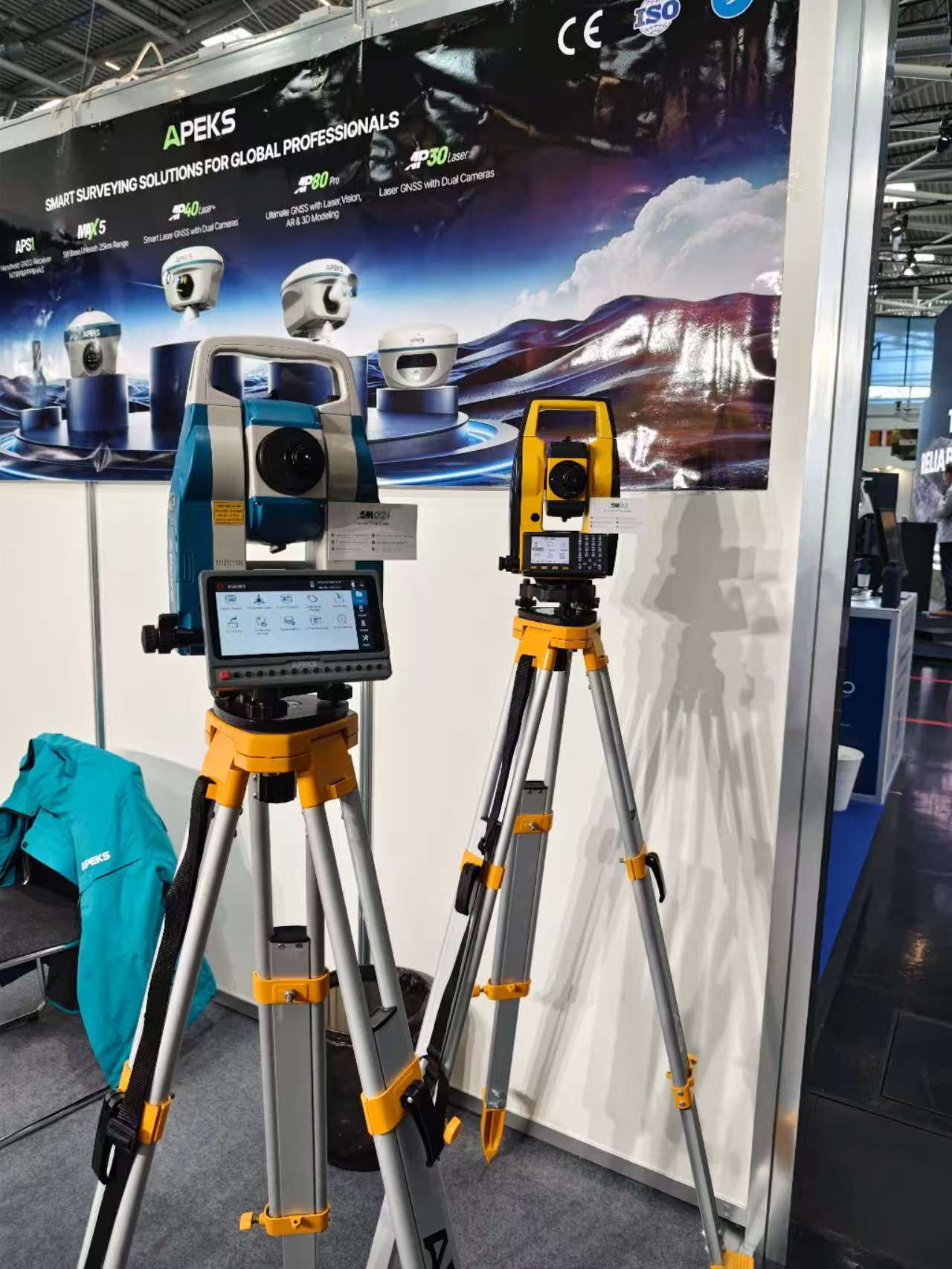APEKS staff explaining AM02i total station setup to visitors at INTERGEO 2026