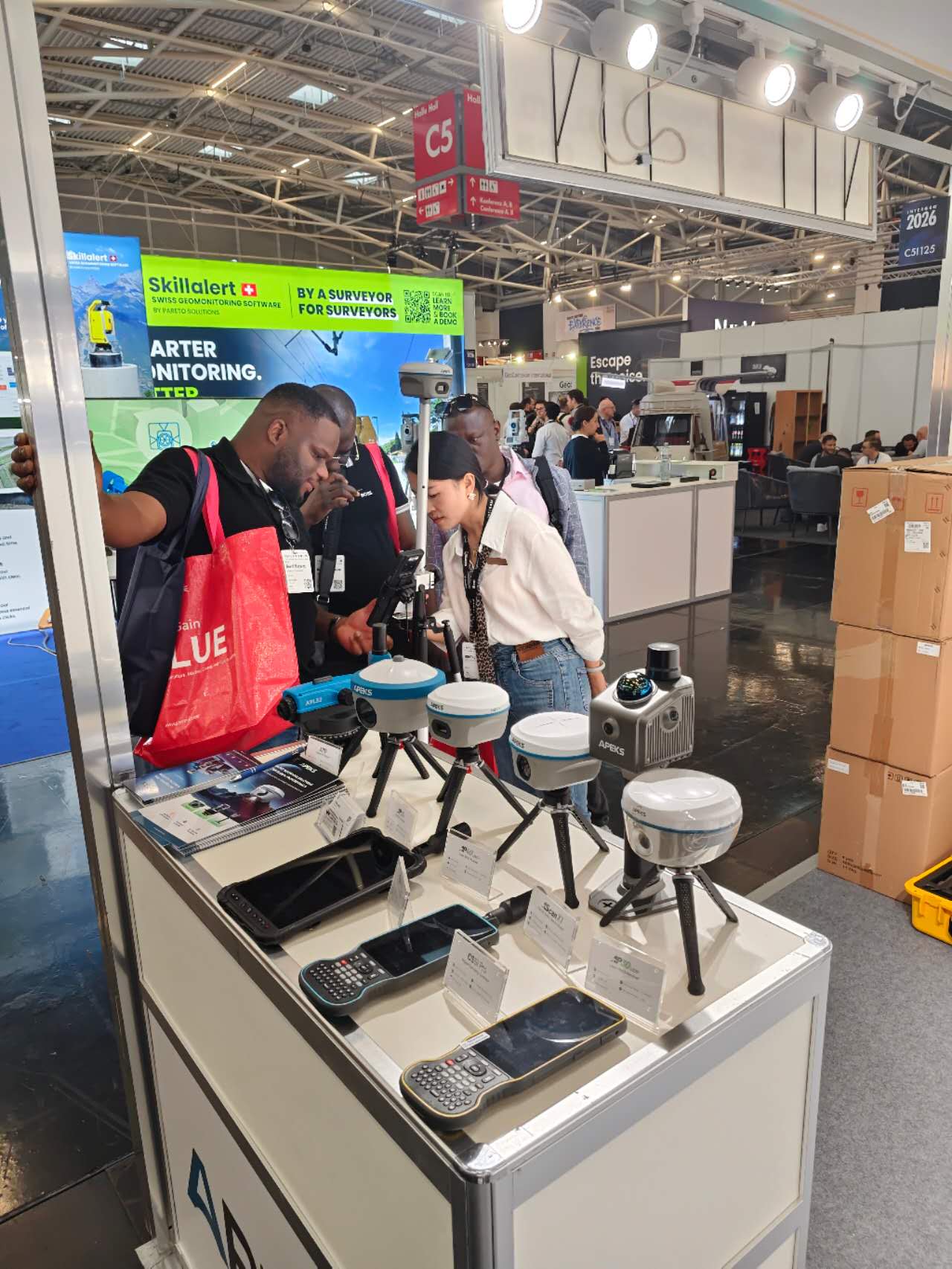 Business card exchange between APEKS staff and a visitor at INTERGEO 2026