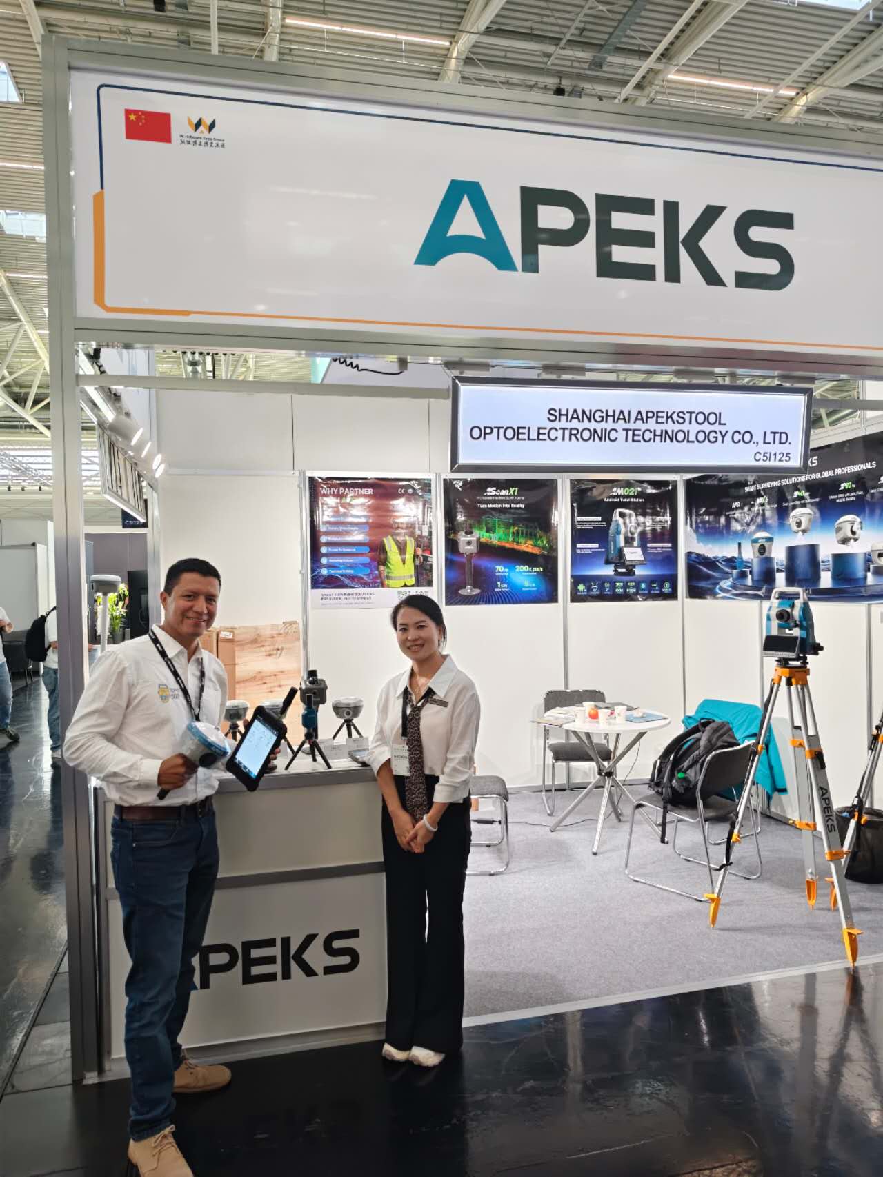 APEKS team and international visitor posing together at Booth C5I125, INTERGEO 2026 Munich