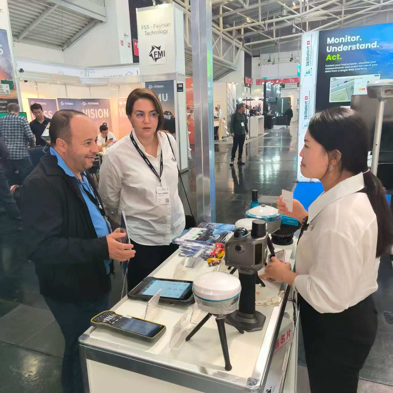 APEKS staff explaining RTK GNSS receiver specifications to visitors at INTERGEO 2026