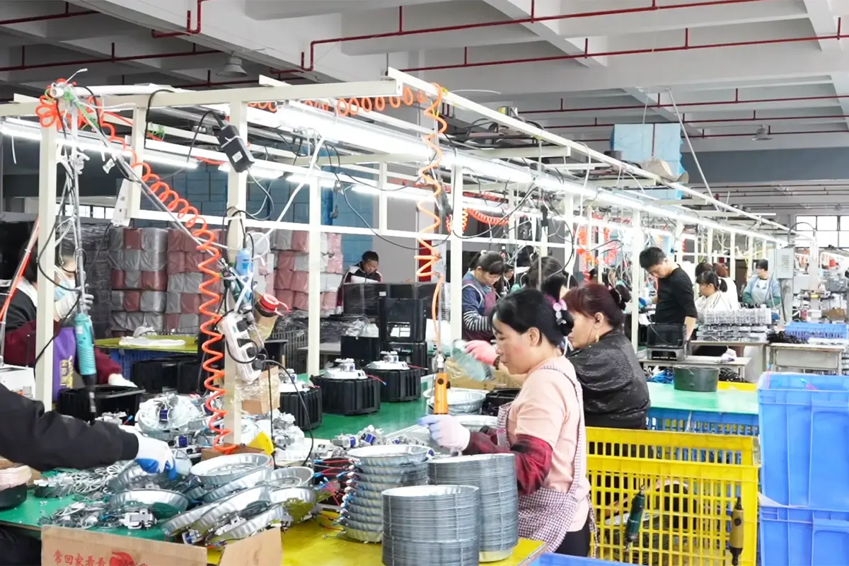Workers assembling air fryer heating components and appliance parts on production line
