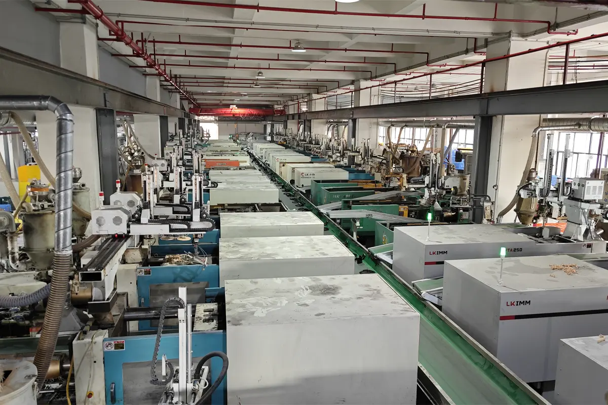 Wide view of APEXDURA injection molding workshop with molding machines and conveyors