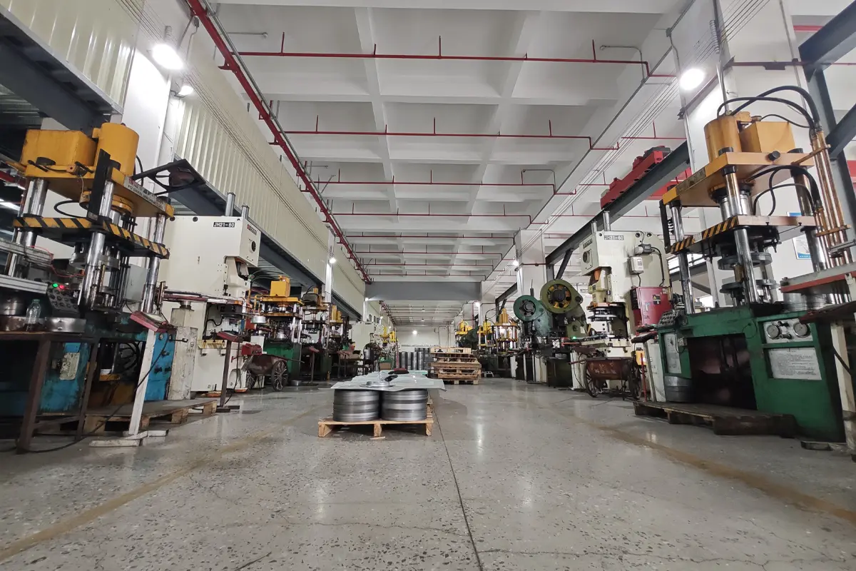 Wide view of APEXDURA metal stamping workshop with presses and material pallets