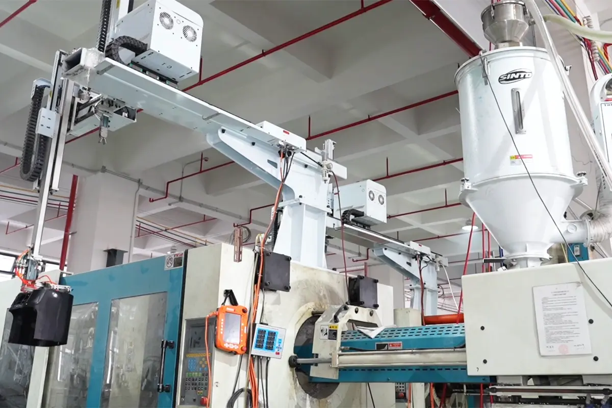 Injection molding machine with take-out equipment and material feeder in APEXDURA workshop