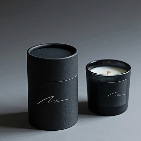 Scatole rotonde nere per candele con imballaggio tubolare ecologico per una presentazione elegante.